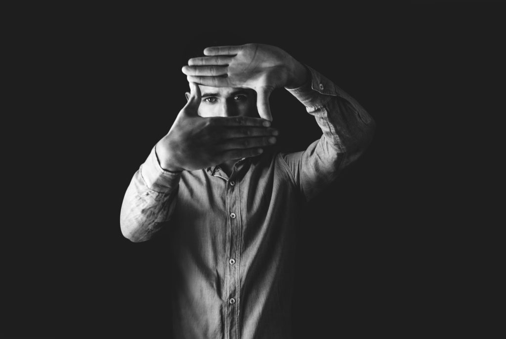 Foto de homem criando uma moldura de imagem com as mãos